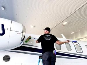 An employee at RealClean Aircraft Detailing scrubs one of the many jets the brand services. 